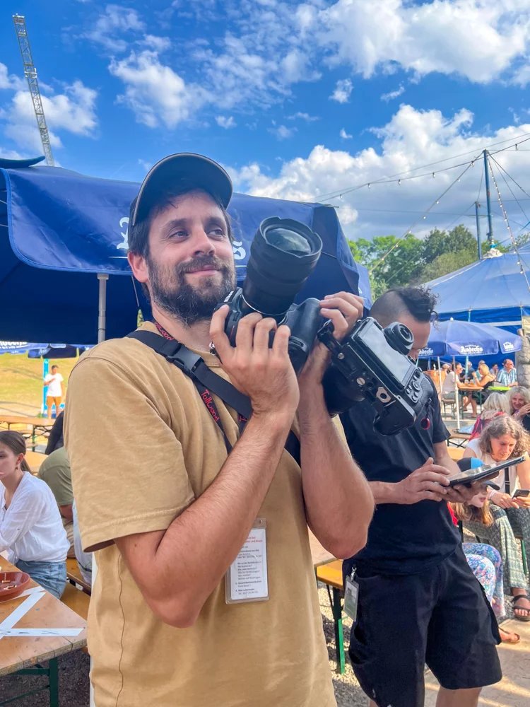 Fotograf Alex Scharf mit Kamera bei einem Event in München